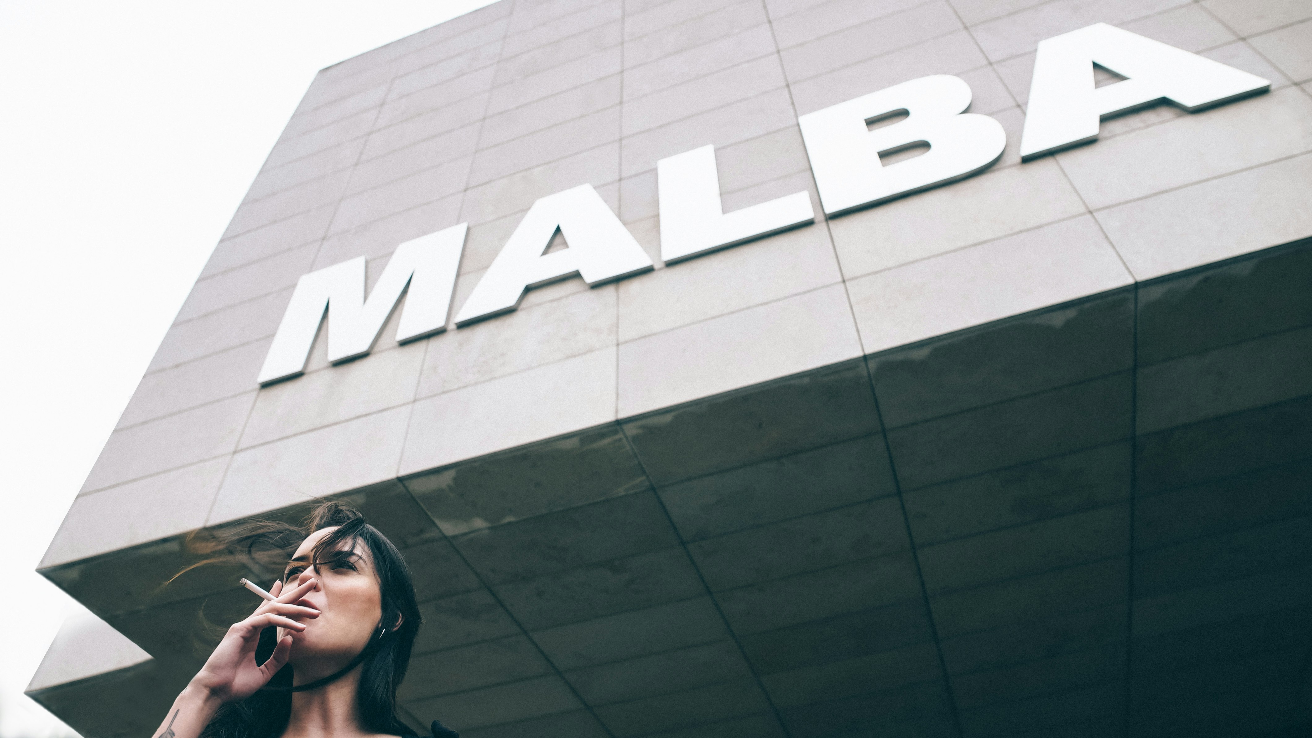 woman taking cigarette near Malba building